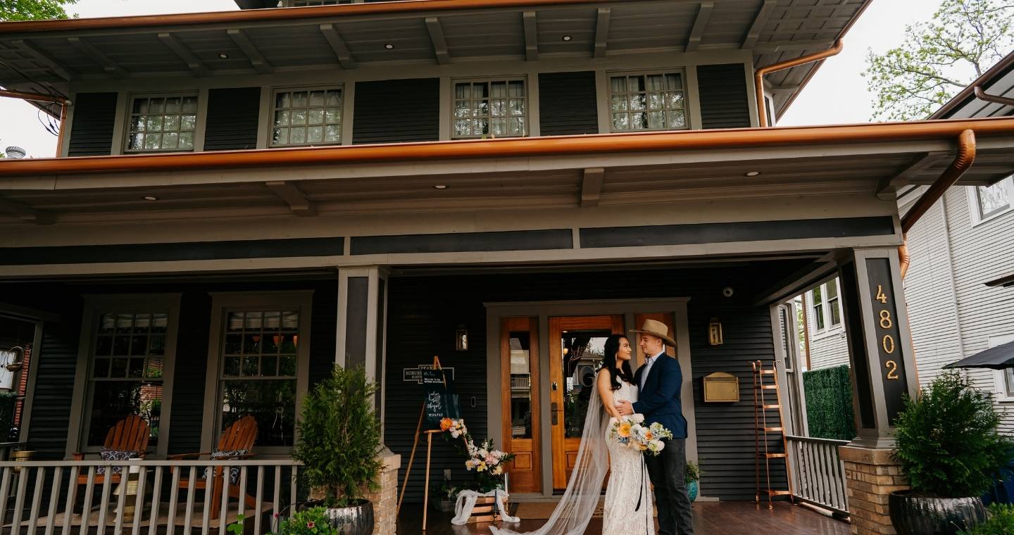 Bride and groom standing on the porch of The Gaston Bed and Breakfast in Dallas