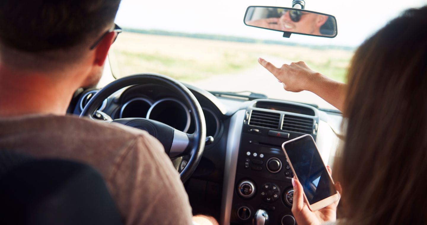 A couple driving pointing at a nearby attraction in Texas