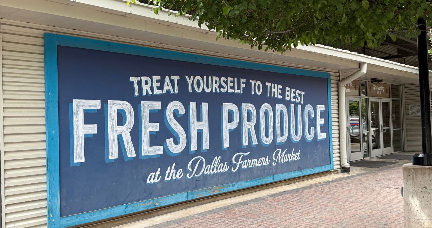 A large sign at the Dallas Farmers market that says "Treat Yourself to the Best Fresh Produce at the Dallas Farmers Market"