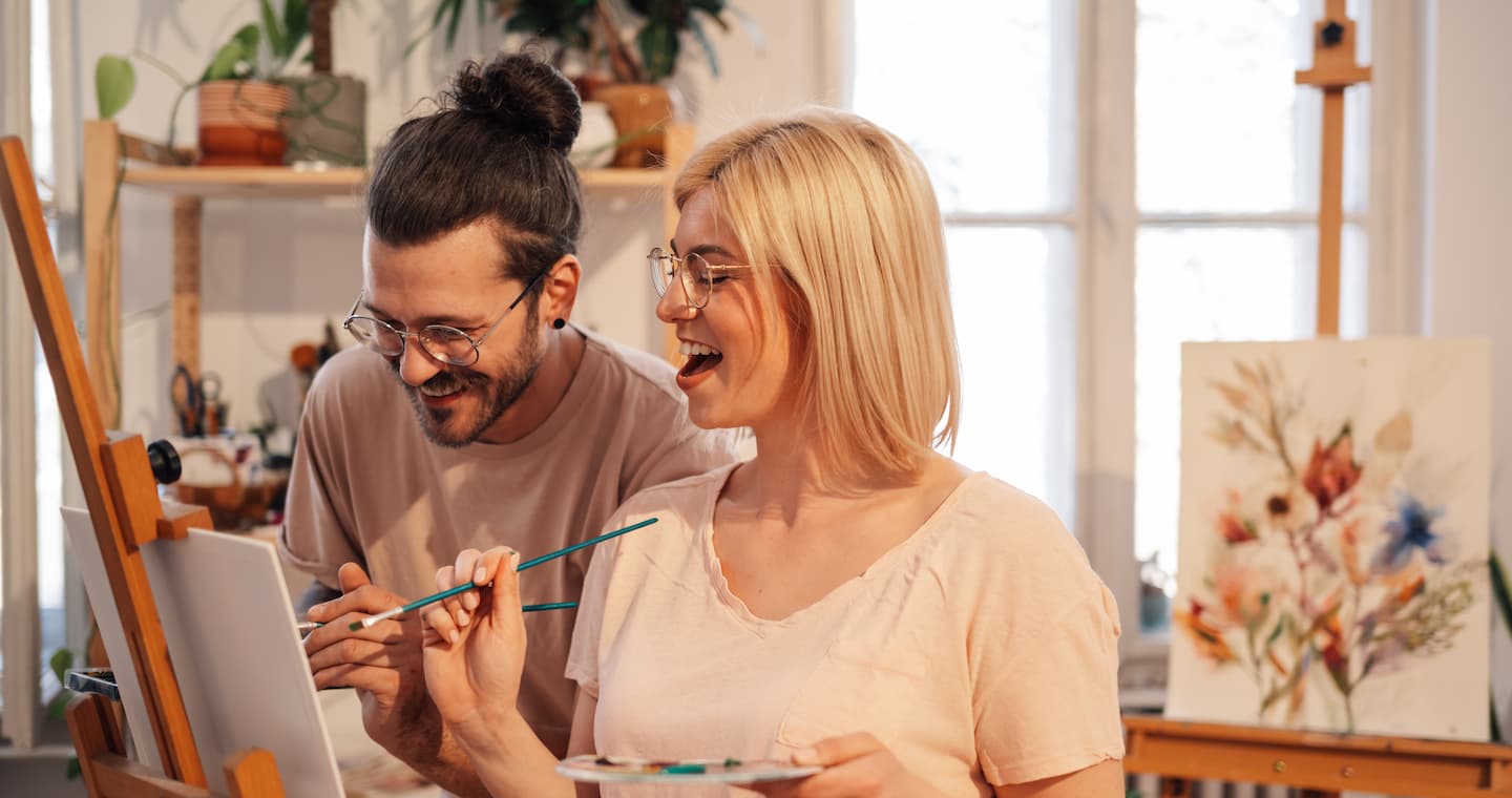 A couple painting on a canvas together on a date in Dallas